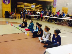 Katarina sits with other Cadettes as their cars race down the track.